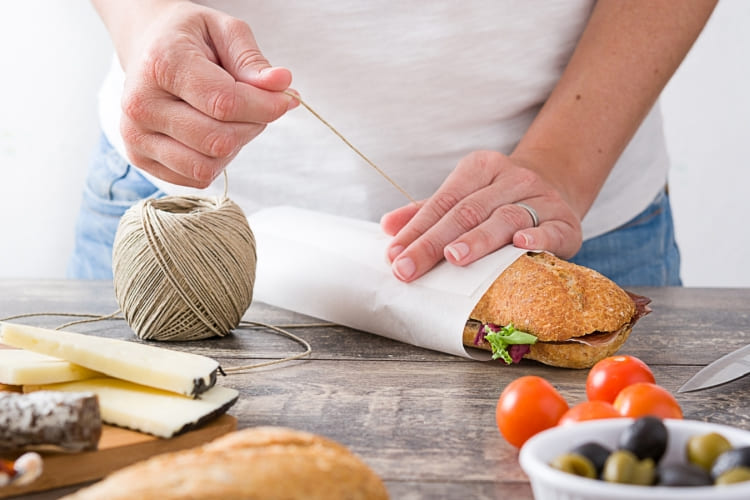 Sandwich wird in Butterbrotpapier eingewickelt.