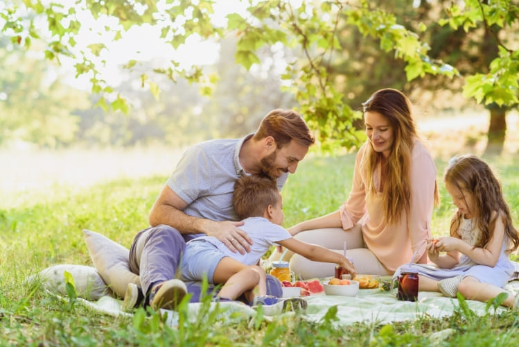 Eine glückliche Familie isst Brote aus Butterbrot-Tüten.