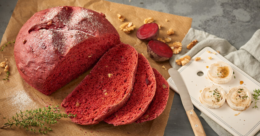 Rote Beete Brot auf Backpapier mit Ziegenkäse auf dem Brett