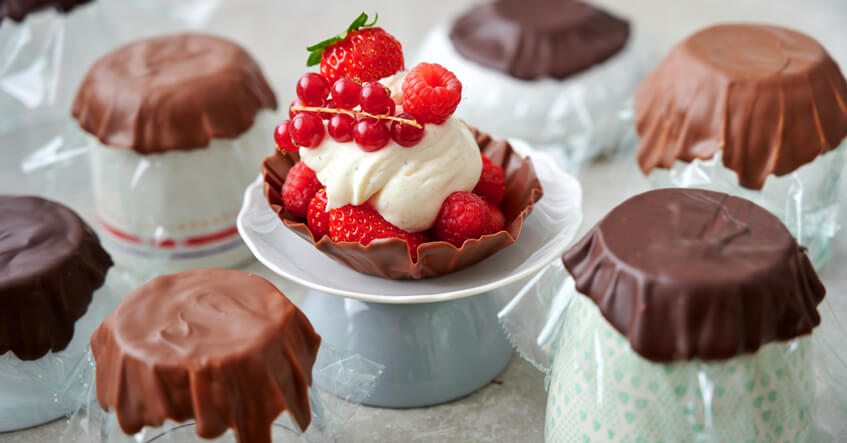 Schokoschälchen auf Frischhaltefolie und passenden Schüsseln oder Bechern und gefüllt mit Mascarponecreme und Beeren.